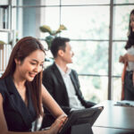 Three professionals in a modern office meeting setting