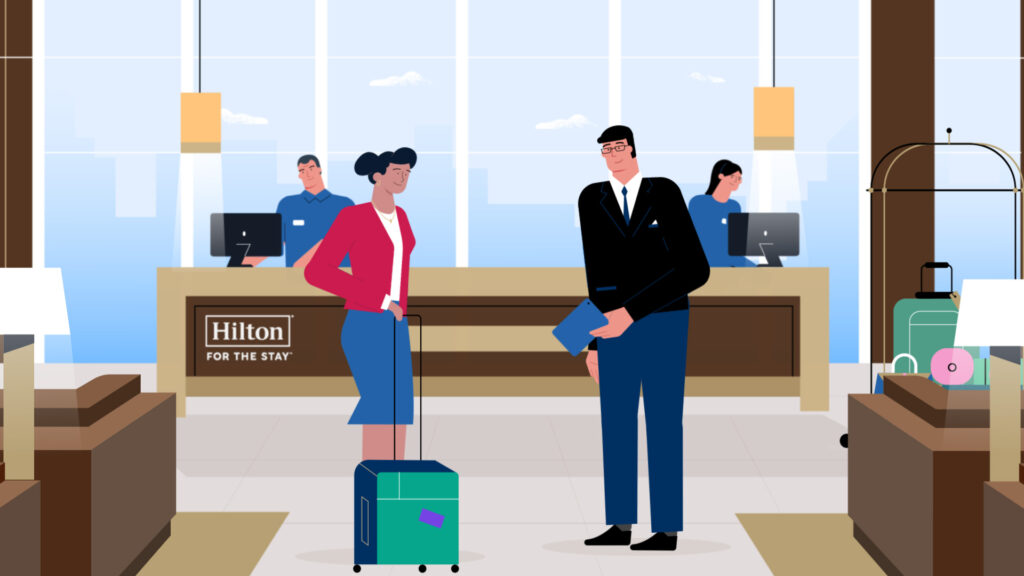 Hotel lobby with guests and staff at front desk, luggage nearby