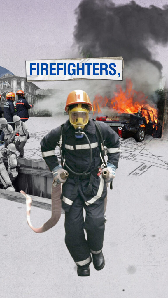 Firefighters in gear stand ready amid smoke and burning vehicle