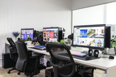 Modern office with multiple desks, computers, and ergonomic chairs