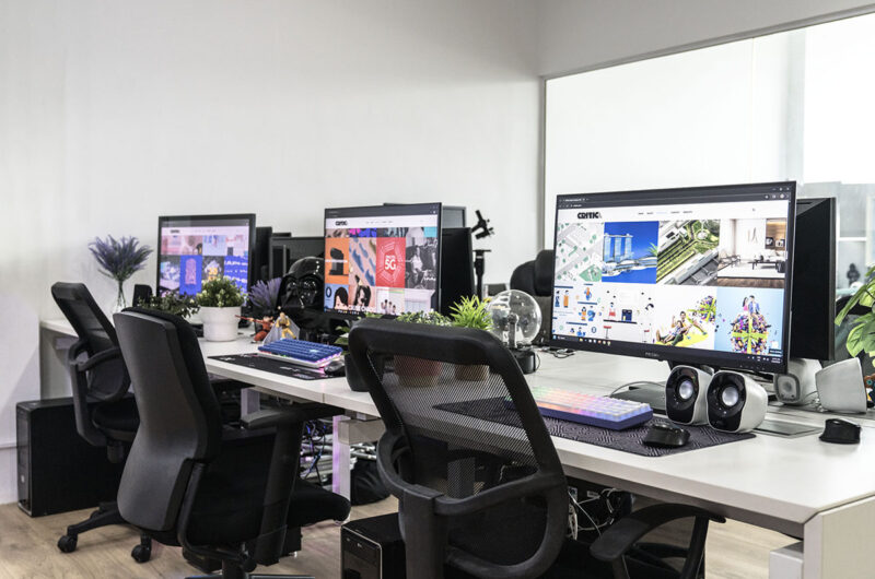 Modern office with multiple desks, computers, and ergonomic chairs