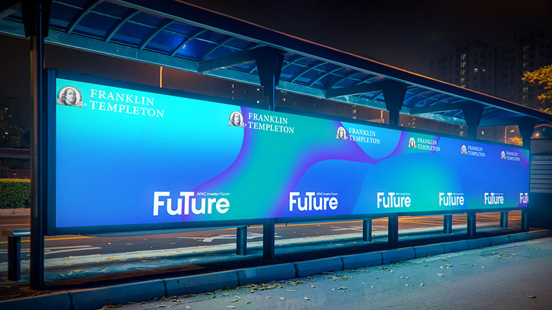 Nighttime bus stop with large digital screen displaying "Franklin Templeton" and "Future" branding
