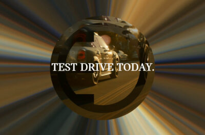 Car reflection in circular frame with "Test Drive Today" text